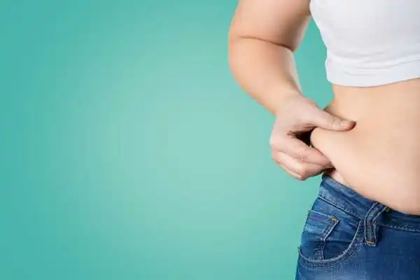 Image of woman pinching her love handles to show weight gain Hickstead